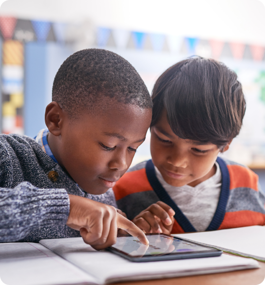 Dos niños usando una tablet juntos en el colegio