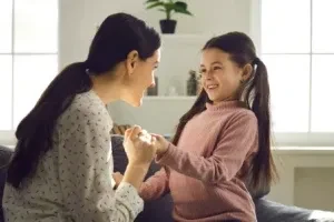 Madre e hija conversando sentadas en un sofá